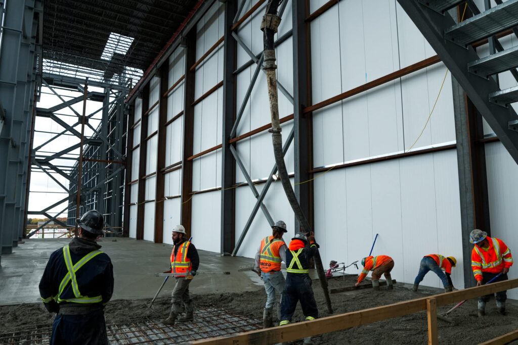 Commercial concrete placing and finishing: crew pouring inside building
