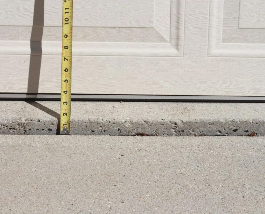 Concrete raising and levelling: tape measure at garage slab edge