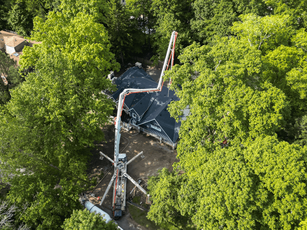 Commercial concrete placing and finishing: aerial pump boom through trees