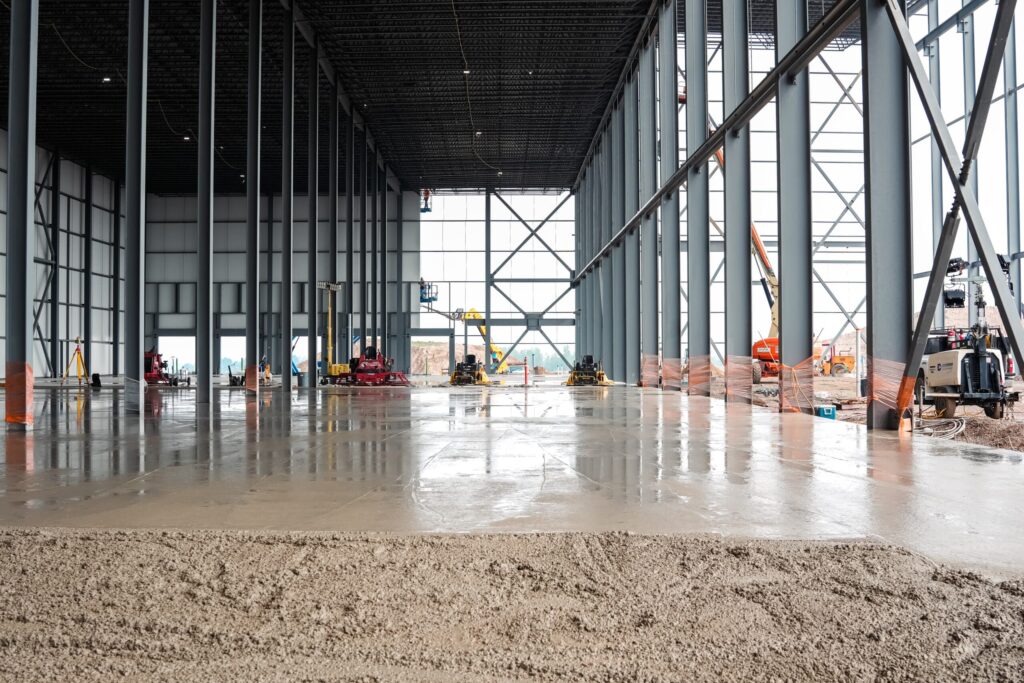 Commercial concrete placing and finishing: steel building interior, wet floor