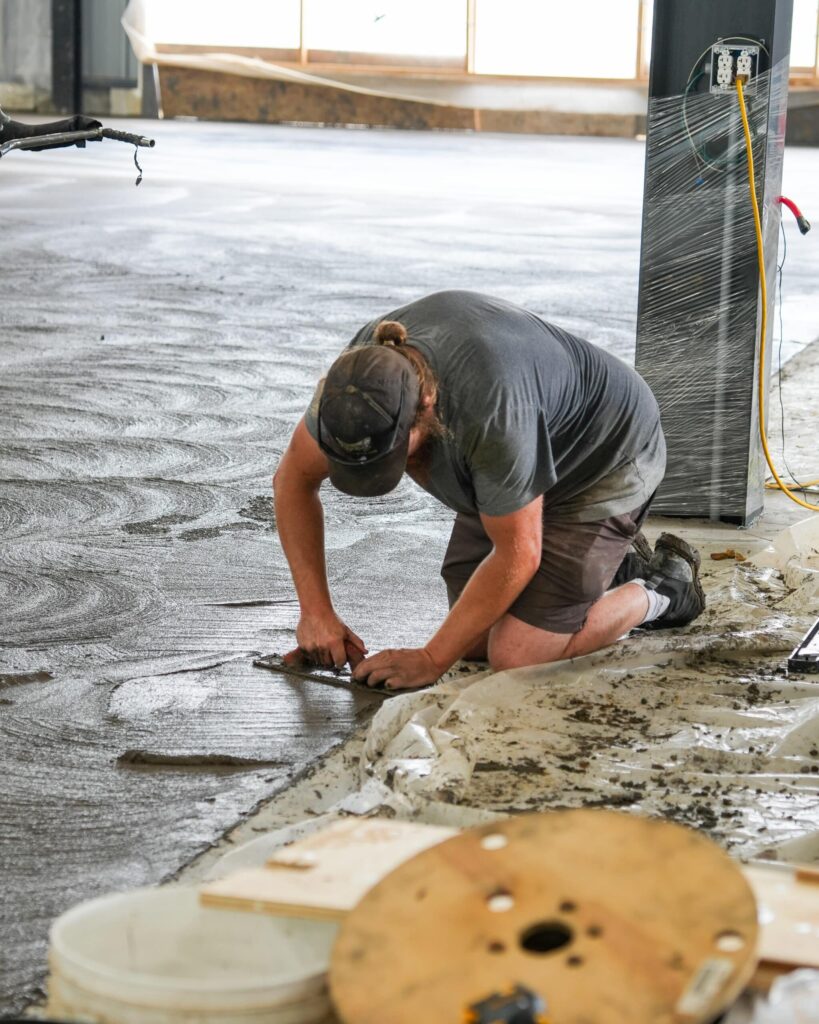 Brosco Concrete crew placing and finishing concrete: worker hand-finishing concrete
