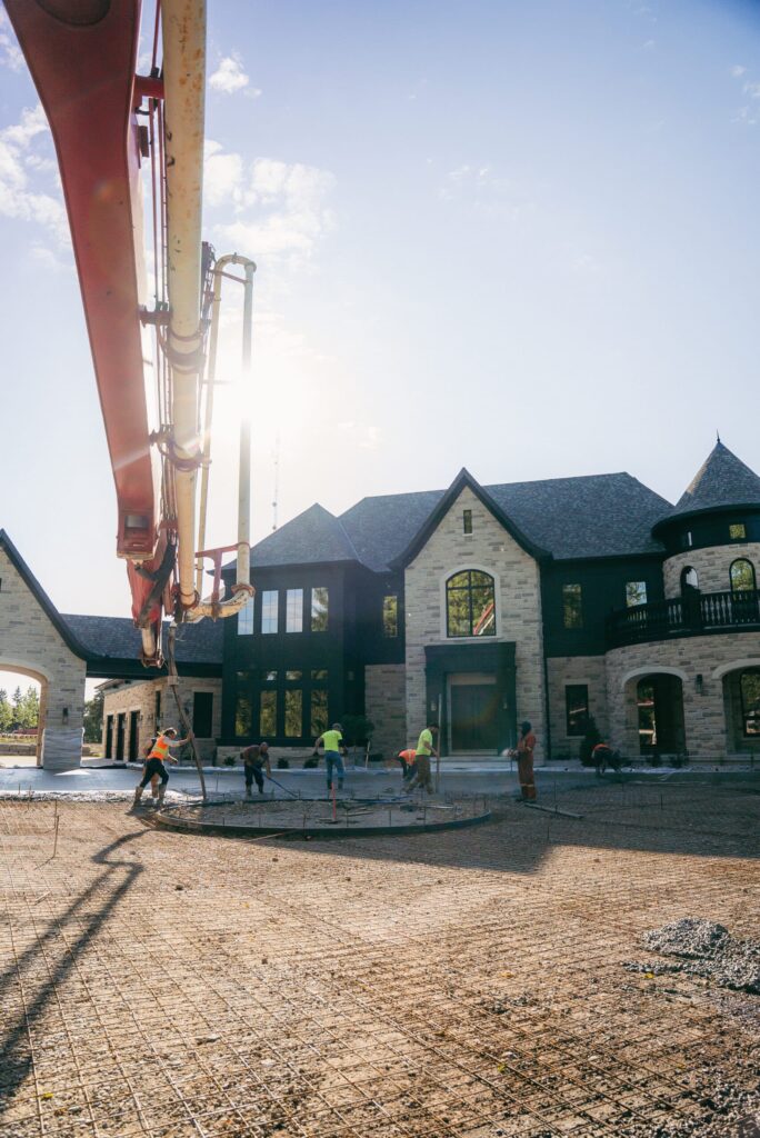 Commercial concrete placing and finishing: pump boom over house under construction