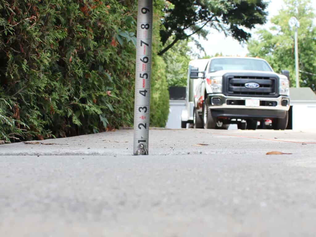 Concrete raising and levelling: tape measure at slab edge, truck