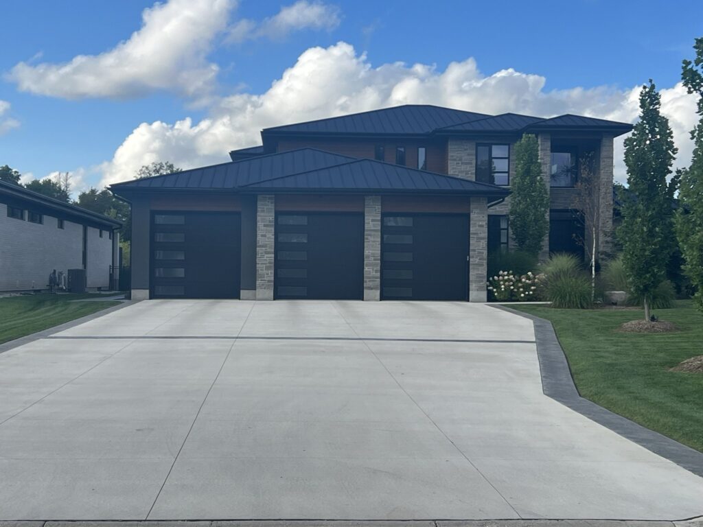 Finished concrete driveway at a three-car garage
