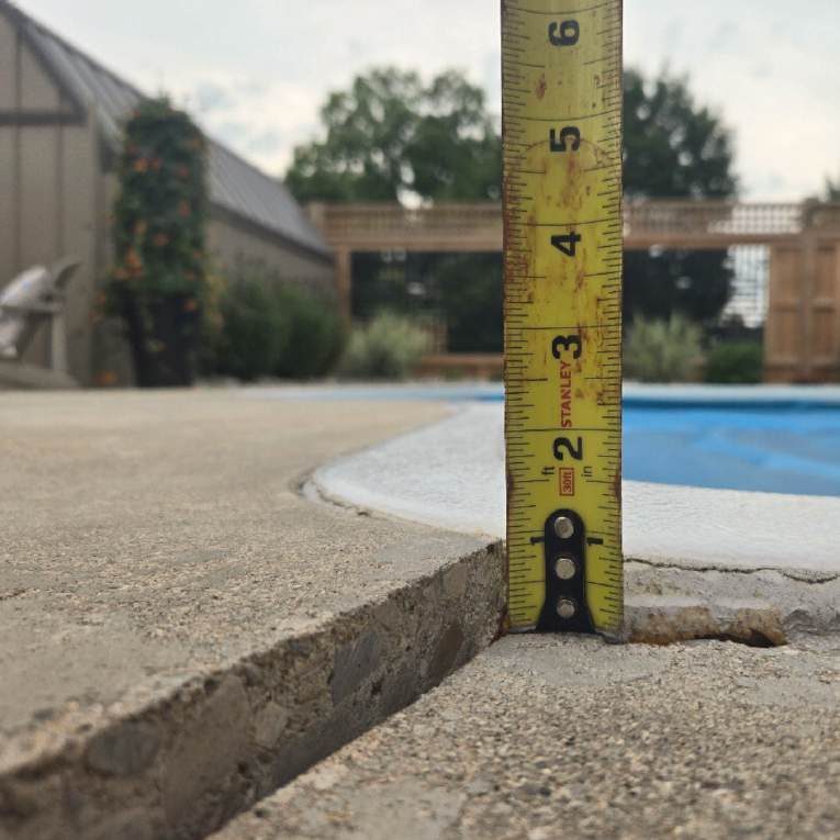 Uneven concrete pool deck before raising and levelling