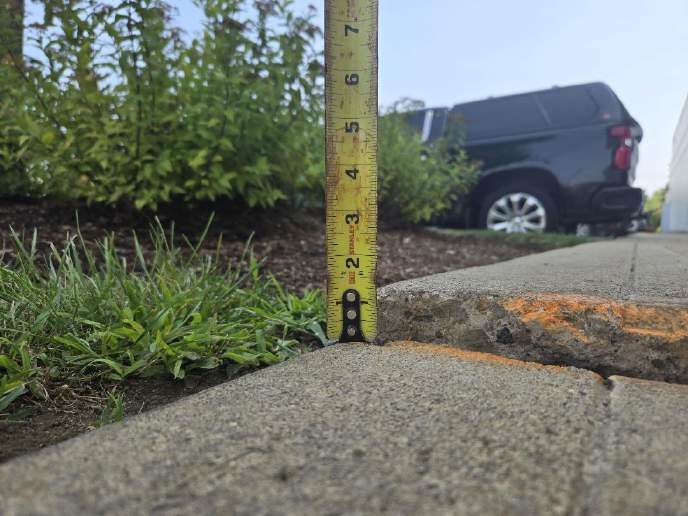 Uneven concrete sidewalk before raising and levelling